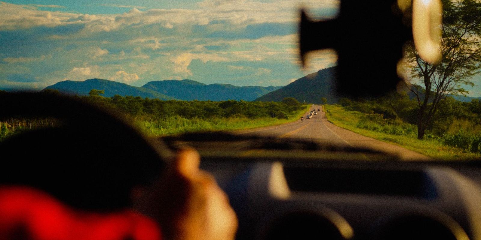 Estrada no interior do Ceará, perto de Sobral, vista pelo para-brisa com serras ao fundo